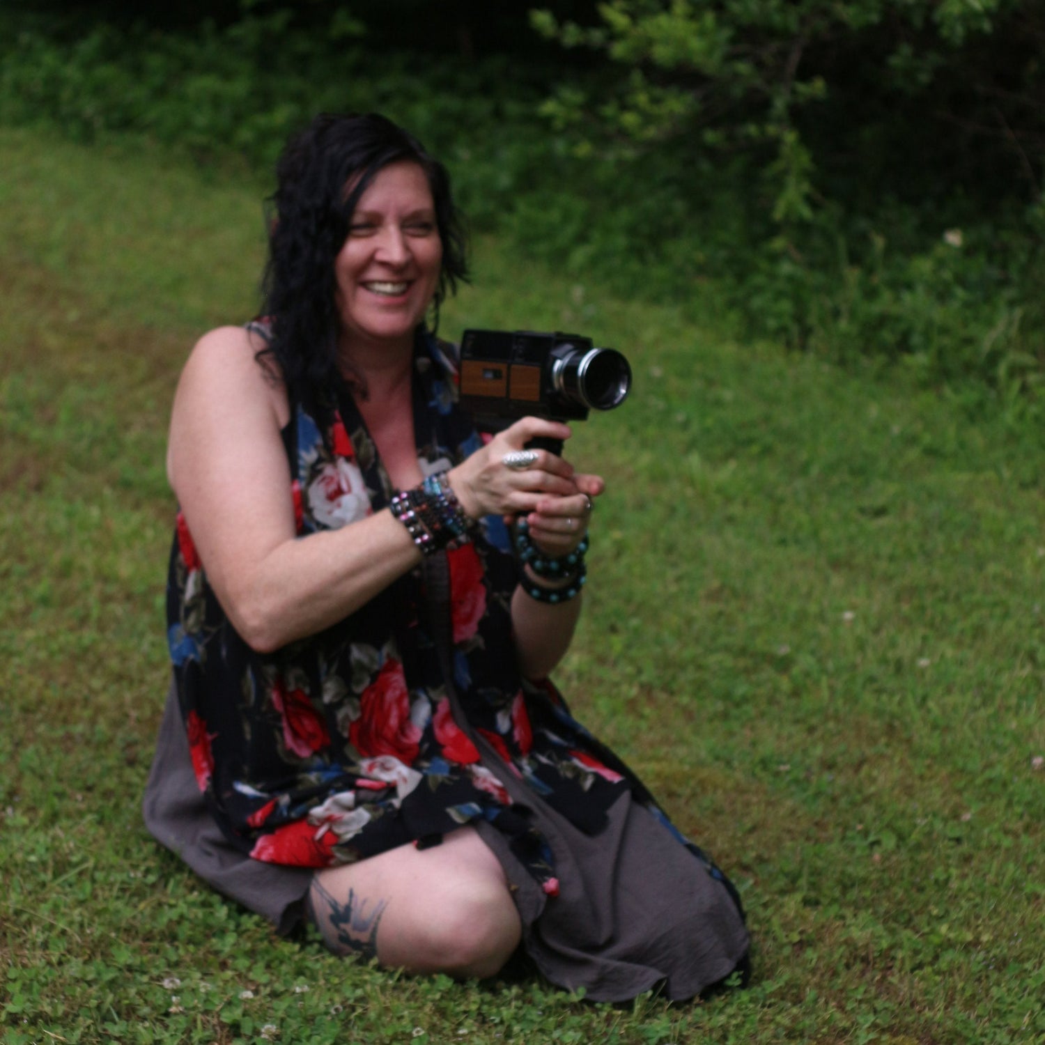 Woman sitting on grass holding a camera