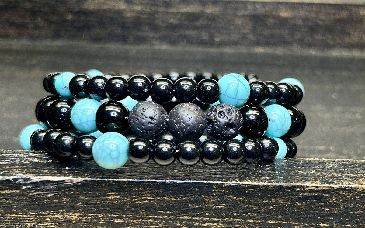 Black and turquoise beaded aromatherapy bracelet on a wooden surface